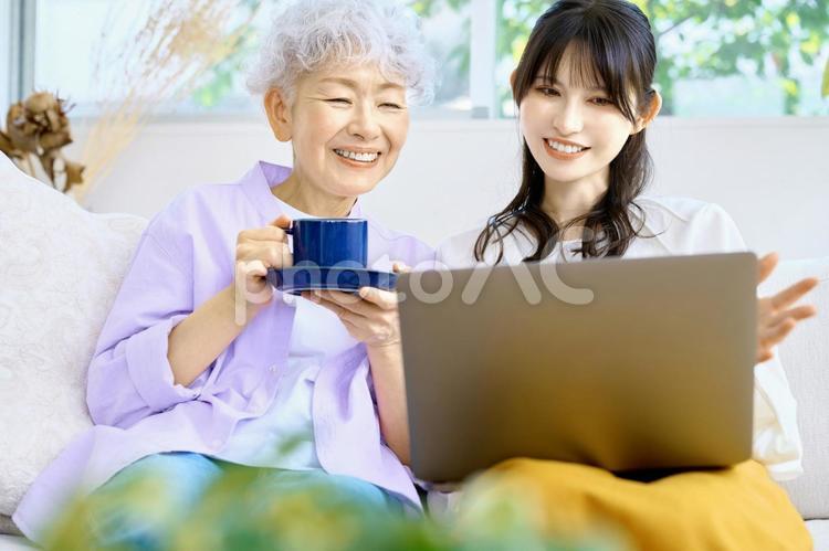 くつろぐ母と娘　嫁と姑　家族　パソコン シニア,家族,親子の写真素材