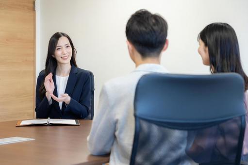若い夫婦と商談をするセールスマン 若い夫婦と商談をするセールスマン セールスマン,会議,ビジネスの写真素材