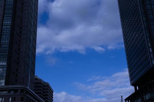 ビル群の隙間から覗く青空の写真