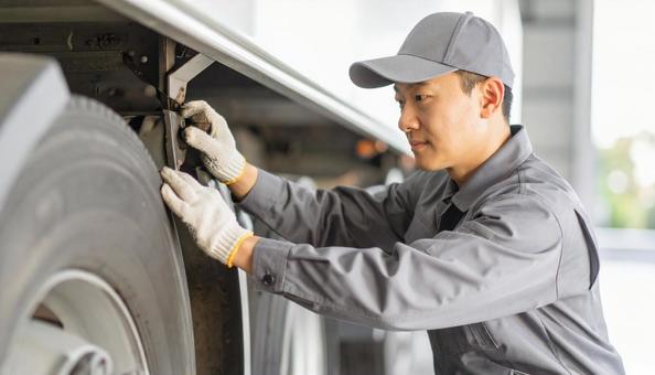 作業服を着たトラックの整備士の写真