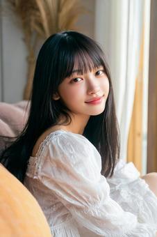 明るい部屋でリラックスする女性の写真