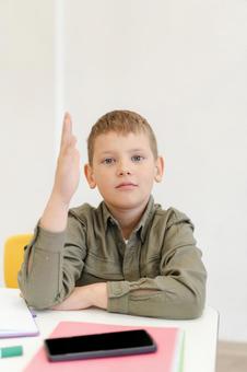 カメラ目線で肘をつけて手を挙げる男の子 男の子,子ども,人物の写真素材