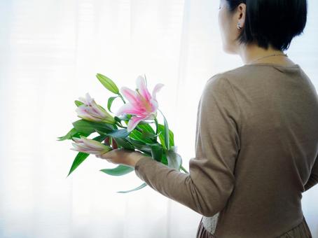 36:ゆりの花を静かに見つめる女性 36:ゆりの花を静かに見つめる女性 花,ゆり,丁寧な暮らしの写真素材