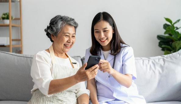 見守り訪問 スマホを使う高齢者とスタッフ 見守り訪問 スマホを使う高齢者とスタッフの写真