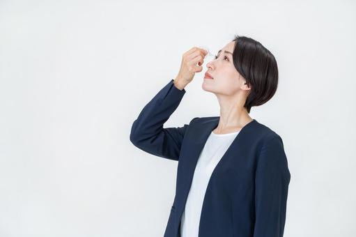 目薬を持つ女性 目薬を持つ女性の写真