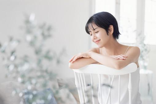 A young woman in a camisole sitting on a chair, JPG A young woman in a camisole sitting on a chair, JPG
