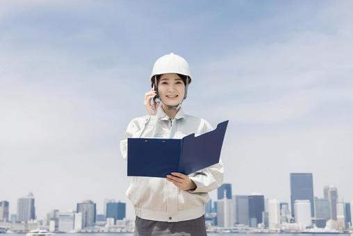 A young woman in work clothes using a smartphone, JPG
