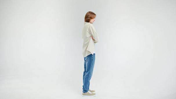 腕組みで立つ横向き男性 腕組みで立つ横向き男性の写真