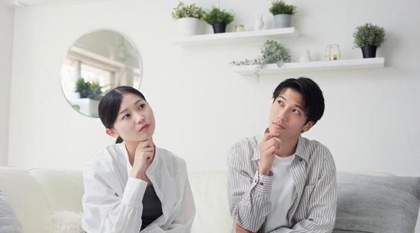 リビングで考え事をするアジア人カップル リビングで考え事をするアジア人カップル 考える,リビング,女性の写真素材