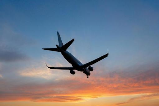 青とオレンジ｜夕焼け空｜飛行機シルエットの写真