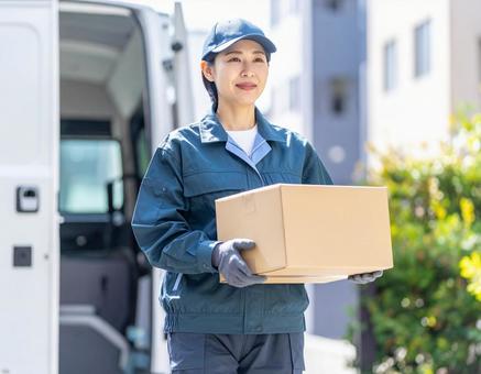 宅配ドライバーとして頑張る女性の配達風景の写真