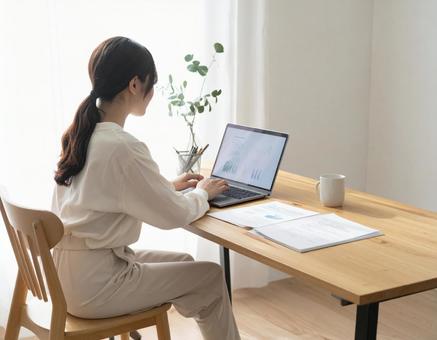 自宅で資料見ながら作業する女性 自宅で資料見ながら作業する女性の写真
