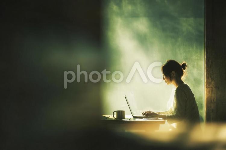 窓辺でPCを使う女性 女性,ノートパソコン,pc作業の写真素材