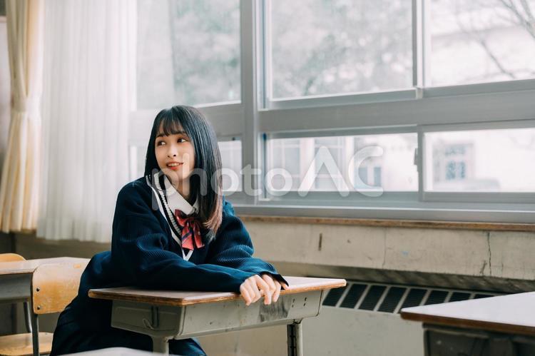 教室で楽しそうに会話する女子高校生 女子高校生,高校生,机の写真素材