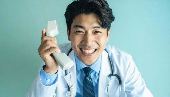 笑顔で固定電話をかける医師 笑顔で固定電話をかける医師の写真