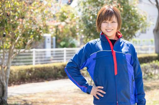 A woman wearing blue work clothes and putting her hand on her waist, mujer, ropa de trabajo, la cara sonriente, JPG