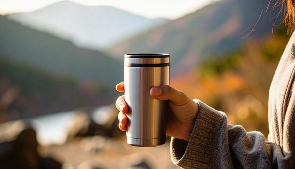 タンブラーを持つ女性の手の写真