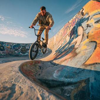 スケートパークで技を決めるBMXライダー スケートパークで技を決めるBMXライダーの写真