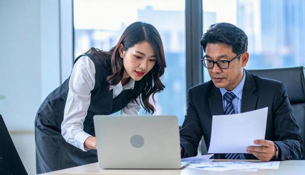 データを見ながら相談する上司と部下 データを見ながら相談する上司と部下の写真