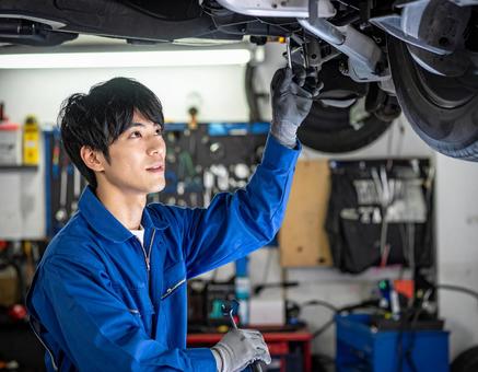 自動車工場でエンジン整備する男性スタッフ 自動車工場でエンジン整備する男性スタッフの写真
