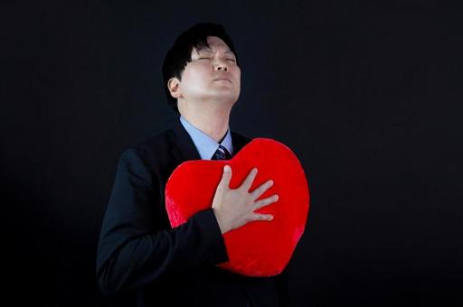 胸にハートを抱く男性 胸にハートを抱く男性 男性,ハート,胸の写真素材