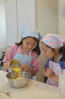 お菓子作りでたまごをそそぐ女の子 お菓子作りでたまごをそそぐ女の子 料理,子供,家庭科の写真素材