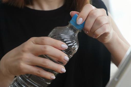 ペットボトルを持つ女性 ペットボトルを持つ女性の写真