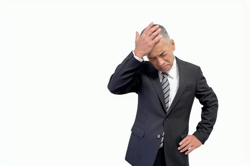 失敗しておでこを抑えるスーツの中年男性 失敗しておでこを抑えるスーツの中年男性 ビジネス,男性,悩むの写真素材