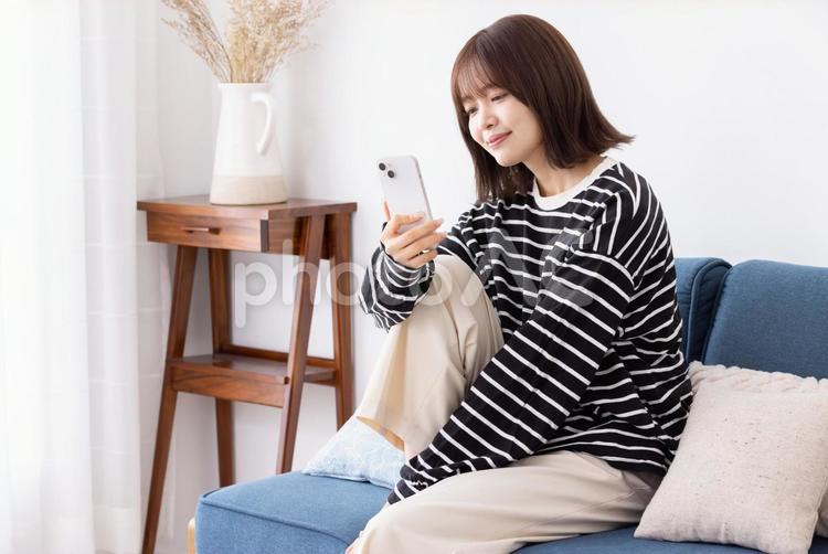 スマートフォンを使う若い女性 女性,スマホ,スマートフォンの写真素材