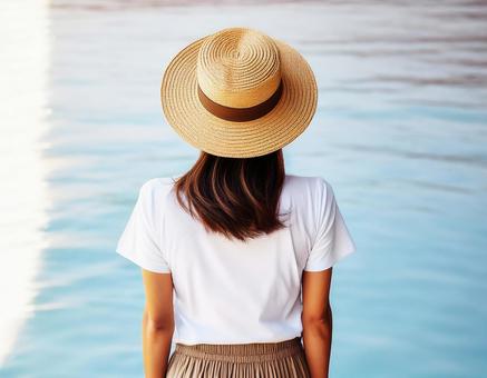白いTシャツに麦わら帽子を被った女性 白いTシャツに麦わら帽子を被った女性の写真