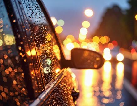 雨に濡れる車と街の光の写真