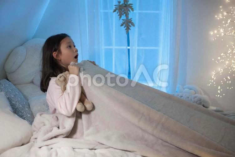 ベッドで毛布を引き上げて怖がる女の子 子ども,女の子,外国人の写真素材