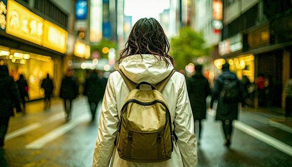 街中を通勤で歩いていくリュック姿の女性 街中を通勤で歩いていくリュック姿の女性の写真
