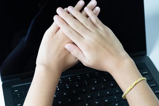 ノートパソコン上で手を重ねる女性 ノートパソコン上で手を重ねる女性 手,重ねる,組むの写真素材