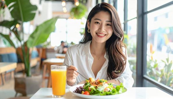 カフェでランチを楽しむ笑顔の日本人女性 カフェでランチを楽しむ笑顔の日本人女性の写真