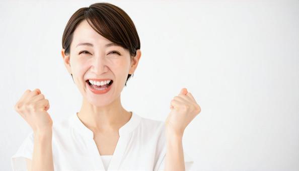 ガッツポーズで喜ぶ笑顔の中年アジア人女性 ガッツポーズで喜ぶ笑顔の中年アジア人女性の写真