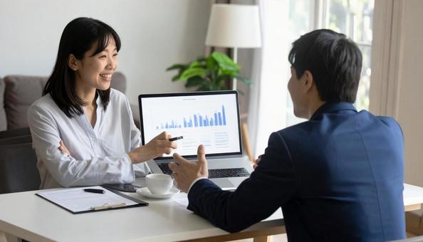 対面でPCでプランを説明するビジネスマンの写真