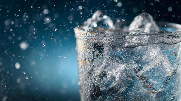 冷たいグラスの縁からあふれる泡立つ水 冷たいグラスの縁からあふれる泡立つ水の写真