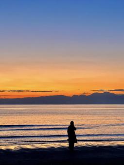 夕暮れの海と人物のシルエット 夕焼け,海,サンセットの写真素材