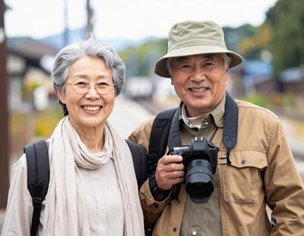 カメラを持って旅する仲良しシニア夫婦の写真