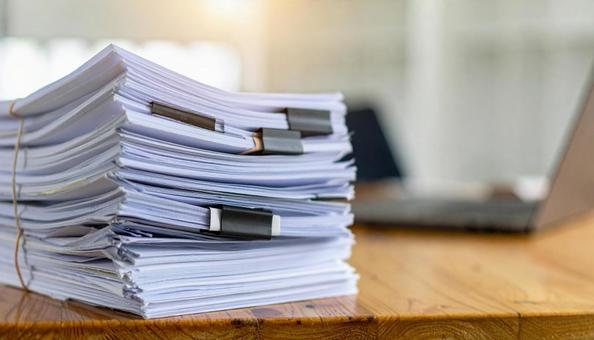 書類まみれの会社の机 書類まみれの会社の机の写真