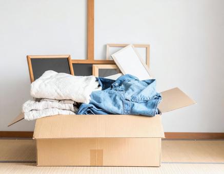 段ボール箱に入れた衣類と本と額縁の写真