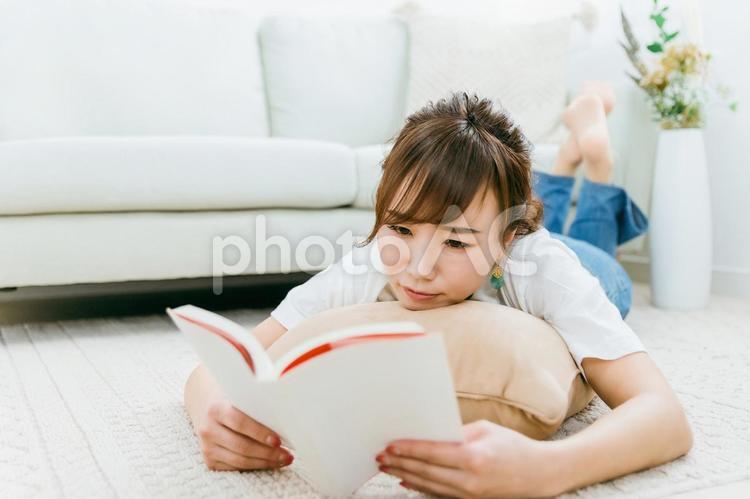 部屋に寝転んで読書をするアジア人女性 読書,本,マンガの写真素材