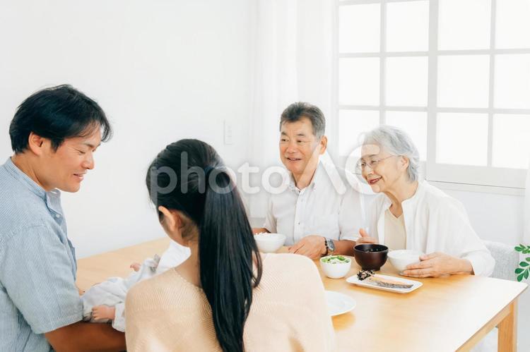 里帰り出産・食事をする老夫婦と若い夫婦 出産祝い,里帰り出産,孫の写真素材
