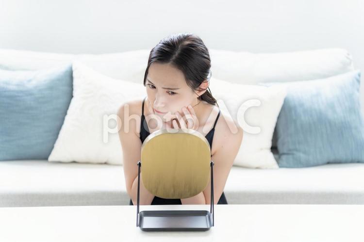 鏡を見て不満げな女性 悩む,自宅,準備の写真素材