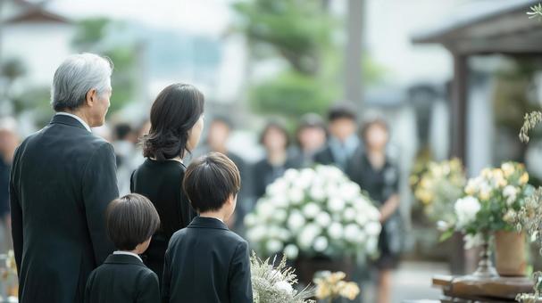 葬儀に参列する家族の後ろ姿の写真