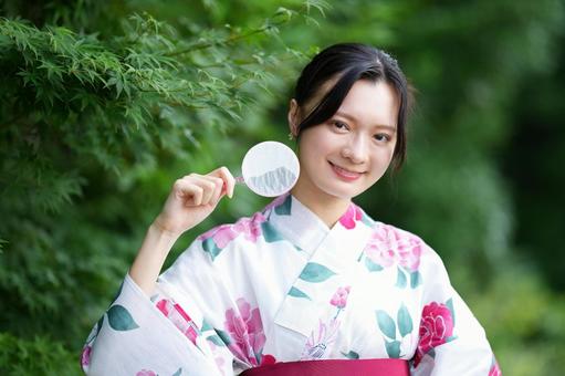 浴衣姿の女性がホイをもって小首をかしげる 女性,浴衣,ポイの写真素材