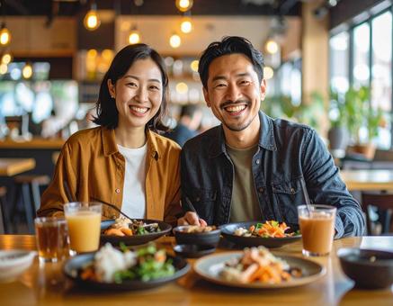 カフェで楽しくランチを楽しむカップル カフェで楽しくランチを楽しむカップルの写真