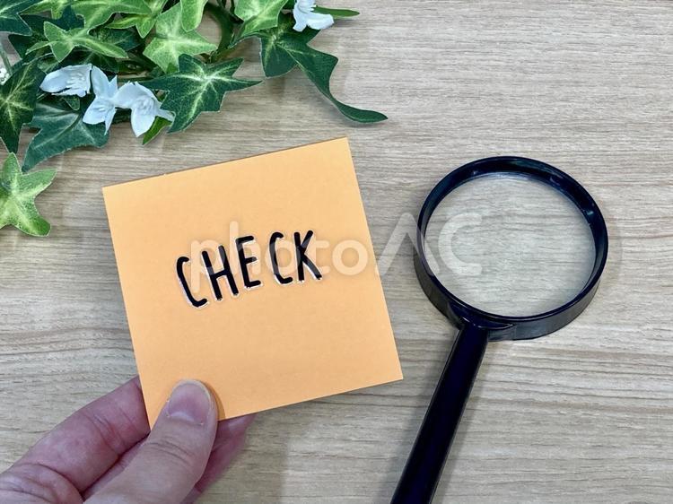 checkと書かれた紙を持つ手元＆虫眼鏡 チェック,虫眼鏡,拡大鏡の写真素材