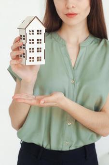 家の模型をアピールする女性スタッフ 保険業,事務職,接客業の写真素材